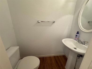 Bathroom featuring dark wood-type flooring and a textured wall