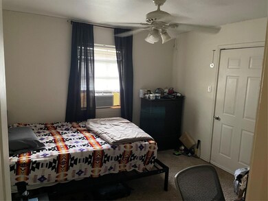 Carpeted bedroom featuring ceiling fan