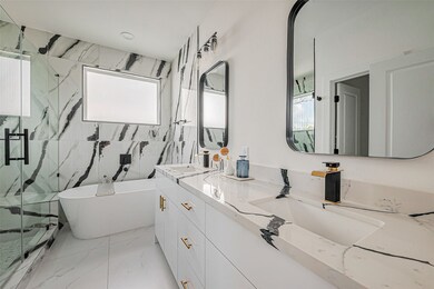 This spa-inspired primary bathroom features a slee