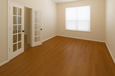 Empty room with wood finished floors and french d