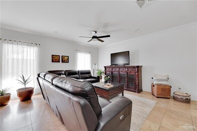 Living room featuring light tile patterned flooring, crown molding, and ceiling fan