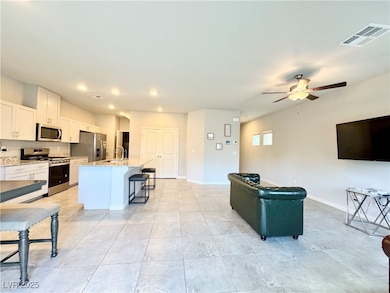 Living area with a ceiling fan, baseboards, and re