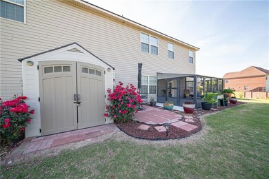Rear view of house featuring a sunroom, a storage 