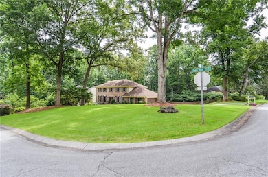 Colonial house featuring a front yard and view of scattered trees