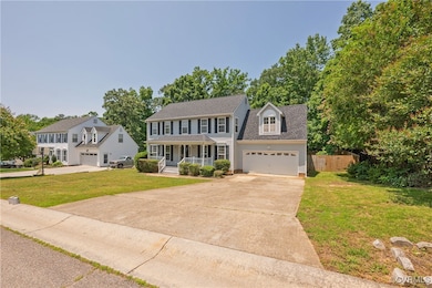 Colonial home featuring a porch, driveway, an atta