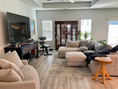 Living room with ceiling fan, plenty of natural li