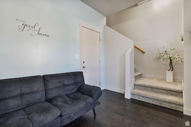 Living room with stairs and dark wood-style floors