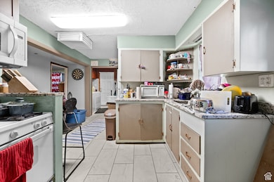 Kitchen with tile floors, gas range, built-in microwave, granite countertops