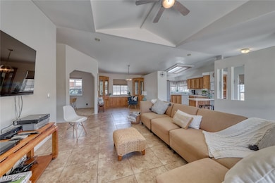 Living room featuring vaulted ceiling, light tile