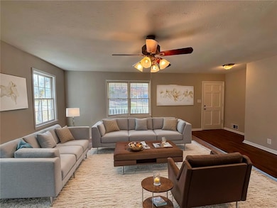 Living room featuring ceiling fan and hardwood / w