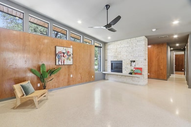 The living area features a stunning wood accent wall that adds warmth and texture, creating a compelling focal point alongside the stone fireplace.