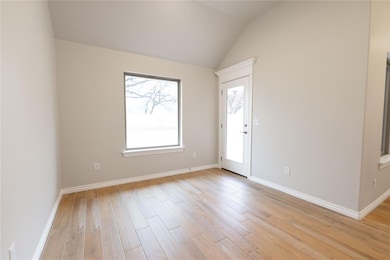Spare room with vaulted ceiling and light wood-typ