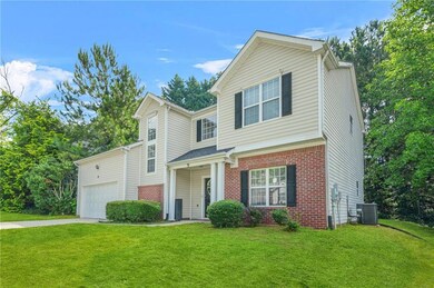 Traditional home featuring brick siding, driveway, a front lawn, and a garage
