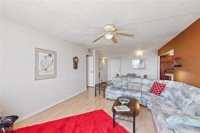 Living area with ceiling fan, visible vents, baseb