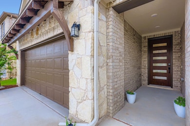 Entrance to property featuring stone siding and a garage