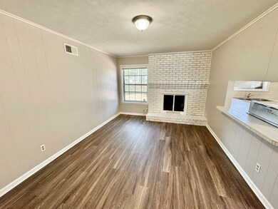 Unfurnished living room featuring crown molding, a