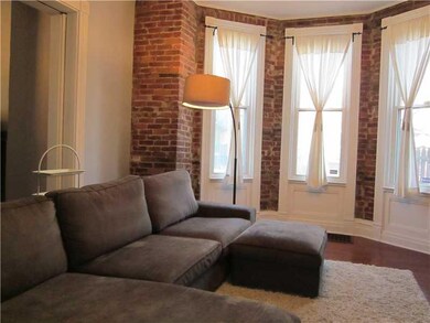 Living Room. Exposed brick, bay window, hardwood f