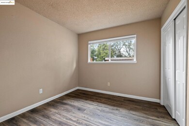 Unfurnished bedroom with a closet, dark wood finished floors, and a textured ceiling