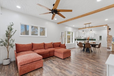Living area with beam ceiling, recessed lighting, dark wood-style flooring, and ceiling fan