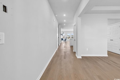 Corridor with light wood finished floors and recessed lighting