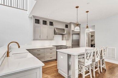 Kitchen with a kitchen bar, tasteful backsplash, hanging light fixtures, a center island, and stainless steel appliances