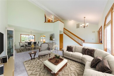 Large living room with vaulted ceilings and open to the equally impressive dining room. Large windows flood the home with natural light.