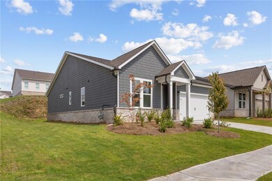 View of front facade with a front lawn, concrete driveway, and an attached garage