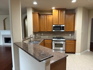 Kitchen with stainless steel appliances, dark sto