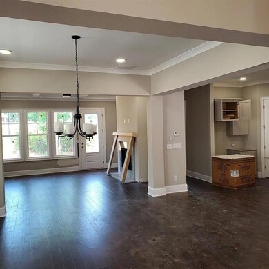 Unfurnished living room with crown molding, a chandelier, baseboards, and recessed lighting