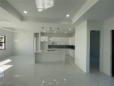 Kitchen featuring sink, white cabinetry, a raised