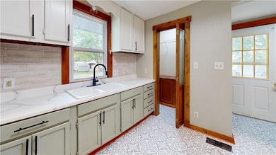 Kitchen with backsplash and light stone countertops