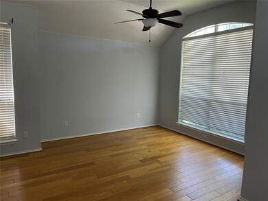 Unfurnished room with ceiling fan, vaulted ceiling, a textured ceiling, and wood-type flooring