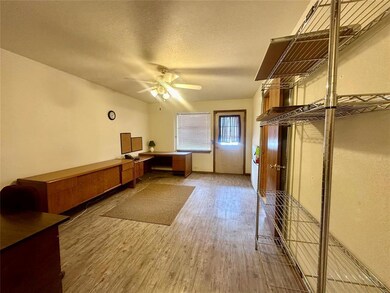 Unfurnished office featuring wood-type flooring, a textured ceiling, and ceiling fan