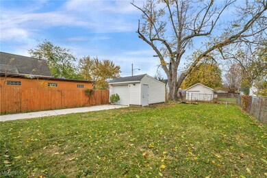 Fenced backyard with an outbuilding and a garage