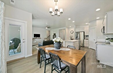 Dining room with light wood-style floors, a chandelier, and recessed lighting