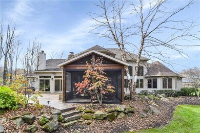 Mature landscaping and patio with fireplace create