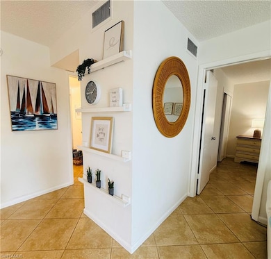 Corridor with light tile patterned flooring, baseb