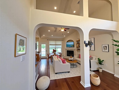 The living room features a wood burning fireplace and leads to the shady backyard.