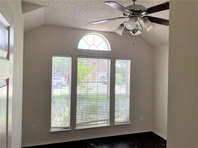 Unfurnished room featuring dark wood-type flooring, a textured ceiling, ceiling fan, and vaulted ceiling