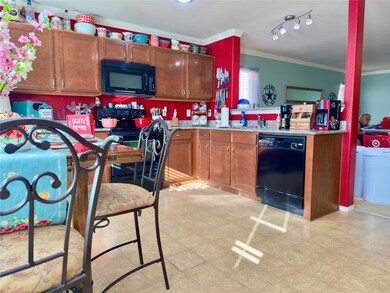 Kitchen with crown molding and black appliances