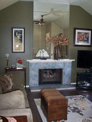 Living room with wood floor, ceiling fan, fireplac
