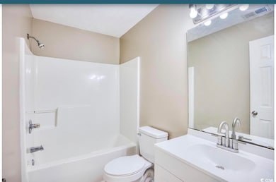 Full bathroom featuring vanity, visible vents, toi