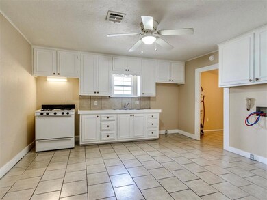 Kitchen with visible vents, white cabinetry, ceili