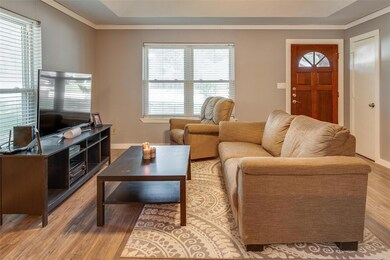 Living room featuring crown molding and light wood-type flooring