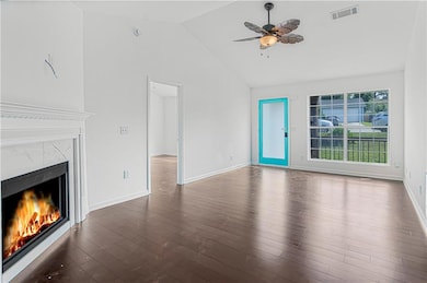 living room featuring a premium fireplace, vaulted