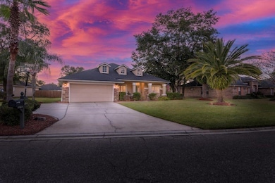View of front of home featuring driveway, a yard, stone siding, and an attached garage
