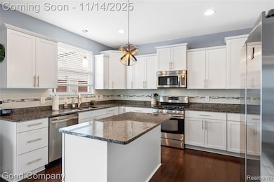 Kitchen with appliances with stainless steel finishes, backsplash, pendant lighting, white cabinetry, and recessed lighting