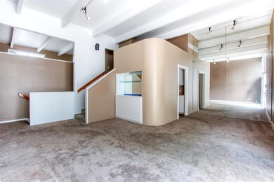 Carpeted spare room featuring beam ceiling and rai