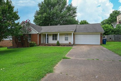Single story home with concrete driveway, an attached garage, covered porch, brick siding, and a shingled roof