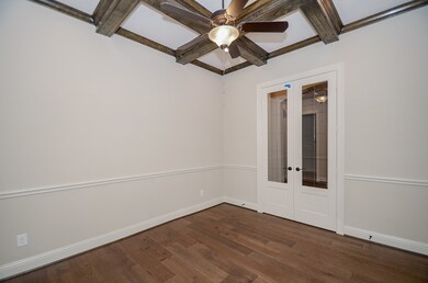 This home office/library/study space just off the main hallway, enchants in an elegantly rustic way! Double, clear paned doors open onto this peaceful, earthy space with wooden beams and extra lighting from the ceiling fan/lighting fixture above.